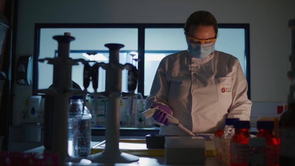 Woman working in a low lit lab by herself