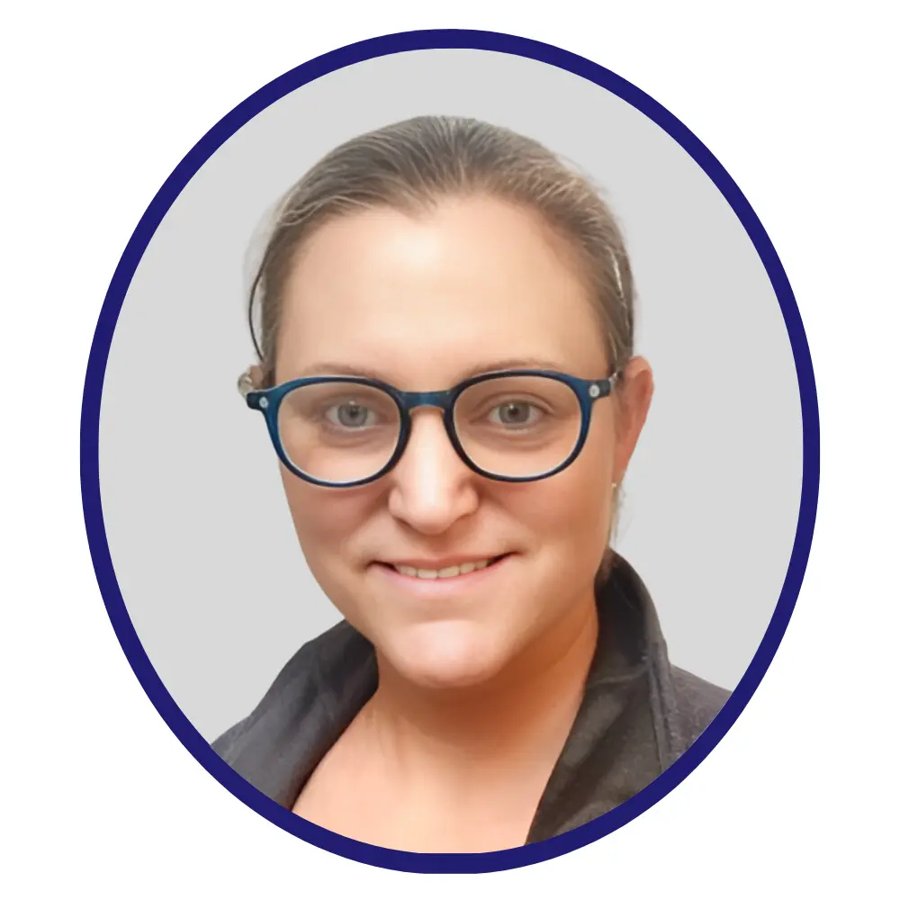 Woman with glasses and tied-back hair, wearing a dark collared shirt, framed in a blue-bordered oval against a light background.