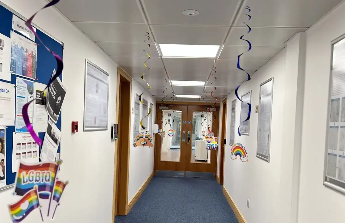 Office hallway adorned with rainbow-themed decorations and LGBTQ+ signage for Pride Month at Pharmaron.