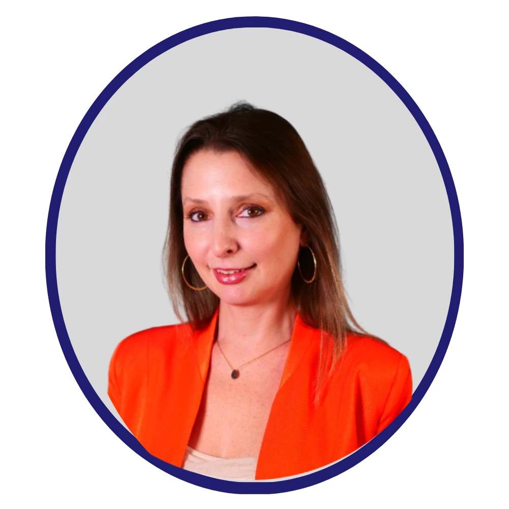Headshot of a brunette woman in a red blazer smiling over a grey background in a blue oval.