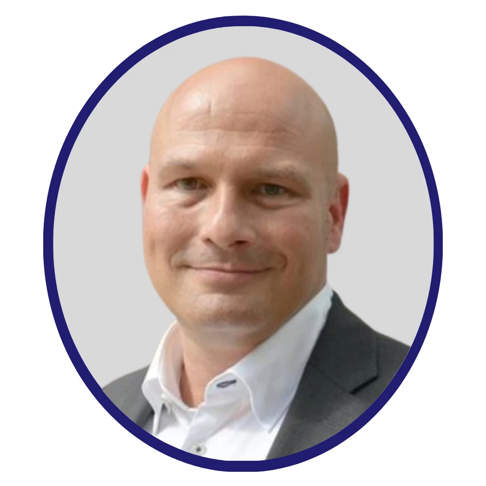 Professional headshot of Pharmaron scientist Florian Schwaak in a gray blazer and white shirt