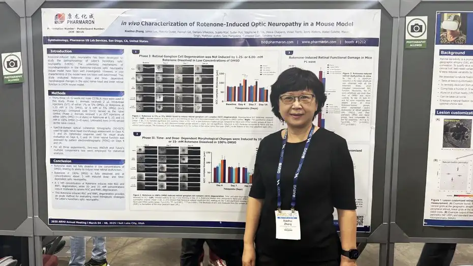 Scientist stands in front of a Pharmaron research poster on rotenone-induced optic neuropathy in mice, featuring charts, methods, and conclusions.