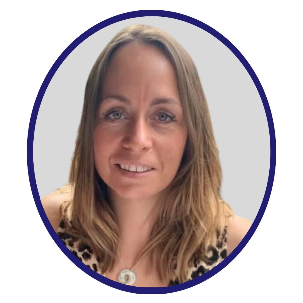 Scientist with light brown hair and leopard-print top, smiling in front of a neutral grey background with a dark blue oval frame.