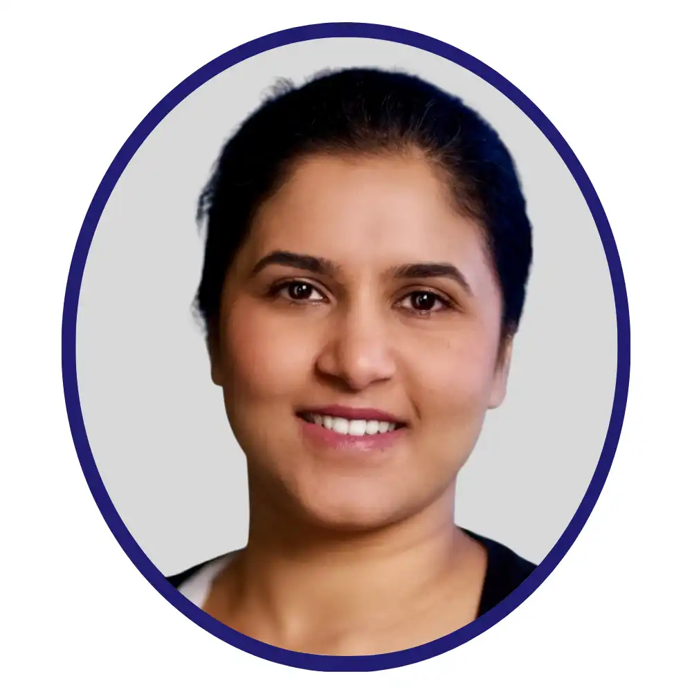 Smiling business development person with dark hair pulled back, wearing a black top, framed by a dark blue oval border on a light gray background.