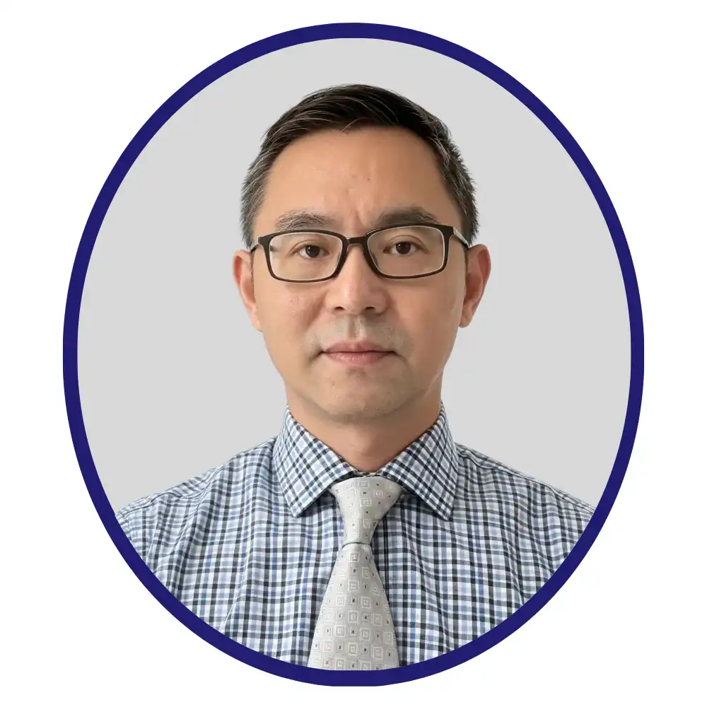 Biopharma professional in glasses, blue checked shirt and light gray patterned tie, navy oval-framed headshot on gray background