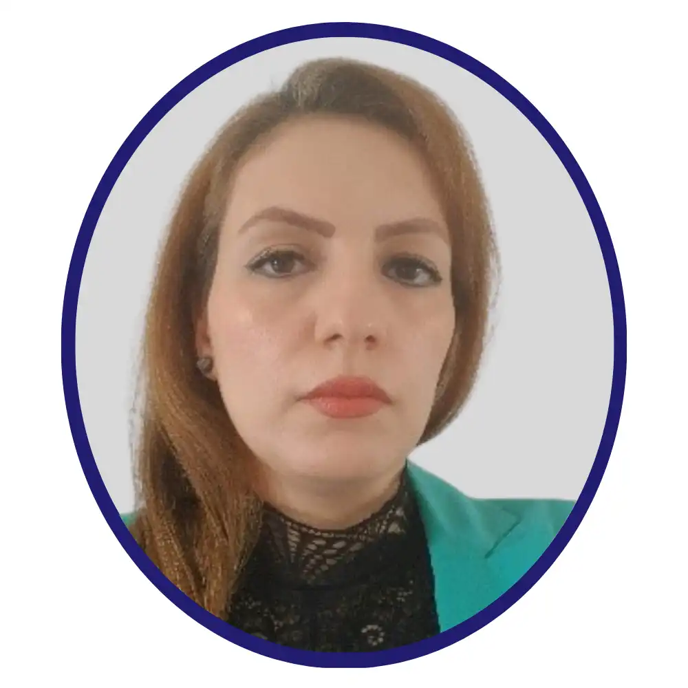 Headshot of a professional with long auburn hair, wearing a teal blazer over a black lace top, framed by a navy oval border on a grey background