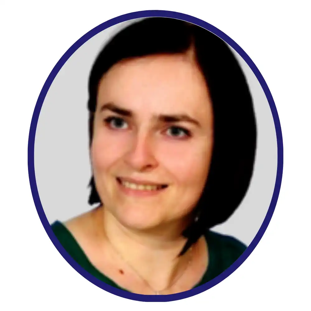 Smiling biopharma professional with a dark bob haircut in a green top, navy oval-framed headshot on gray background
